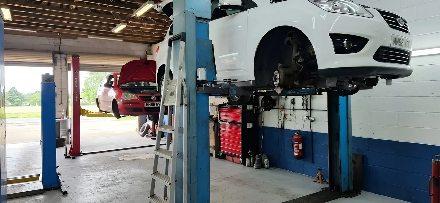 Inside the workshop at Barking Tye Service Station, with a car up on the ramp